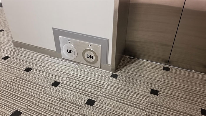 Thang máy với nút bấm đặt ở dưới chân.