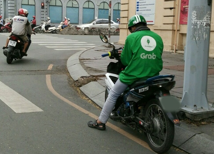 Có khá nhiều bạn trẻ lựa chọn việc làm xe ôm là công việc chính. (Ảnh: báo Lao Động)