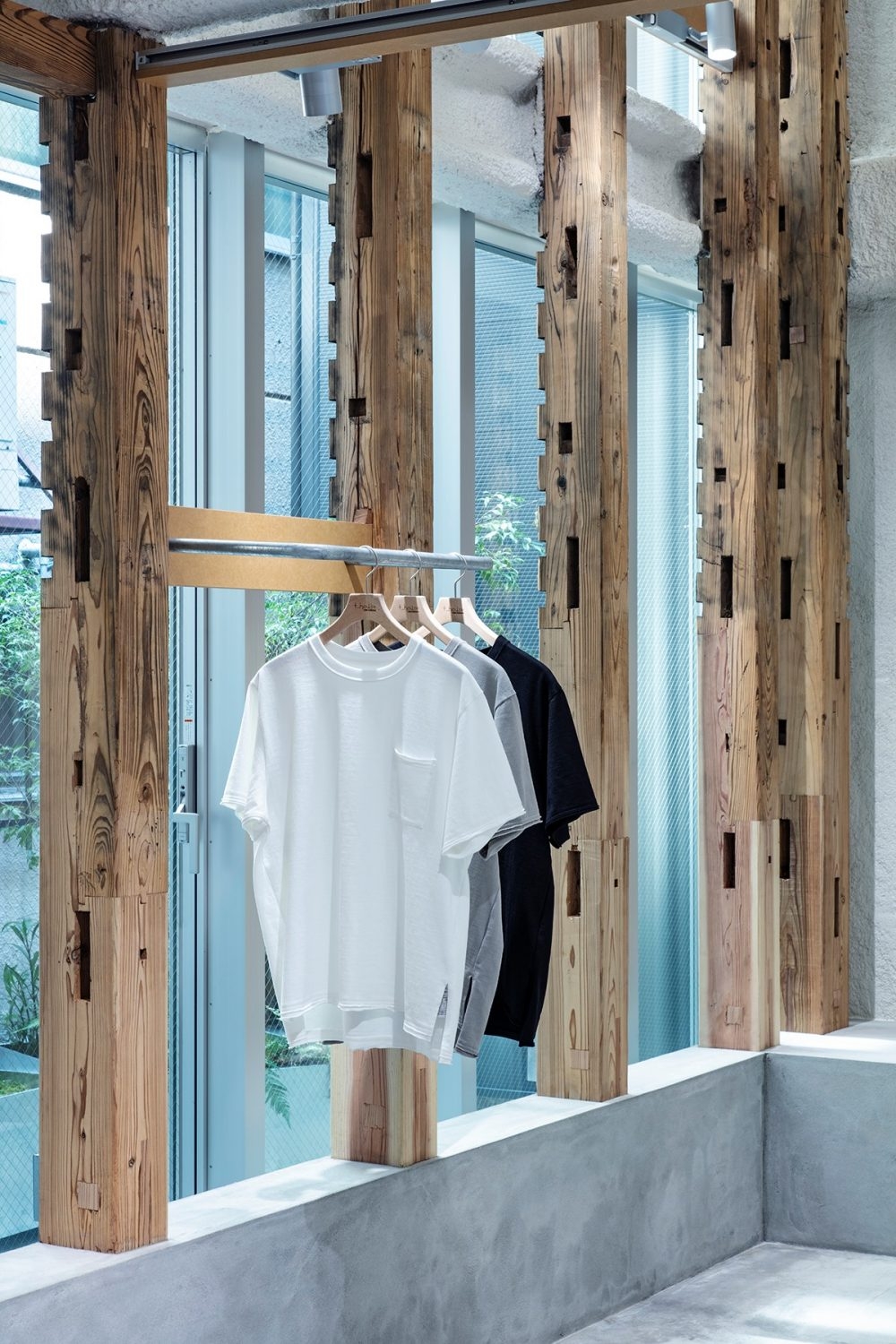 Giữa các khung gỗ có các ô lắp, gia chủ đã tận dụng một cách triệt để làm giá treo quần áo, lưu trữ giày, dép...