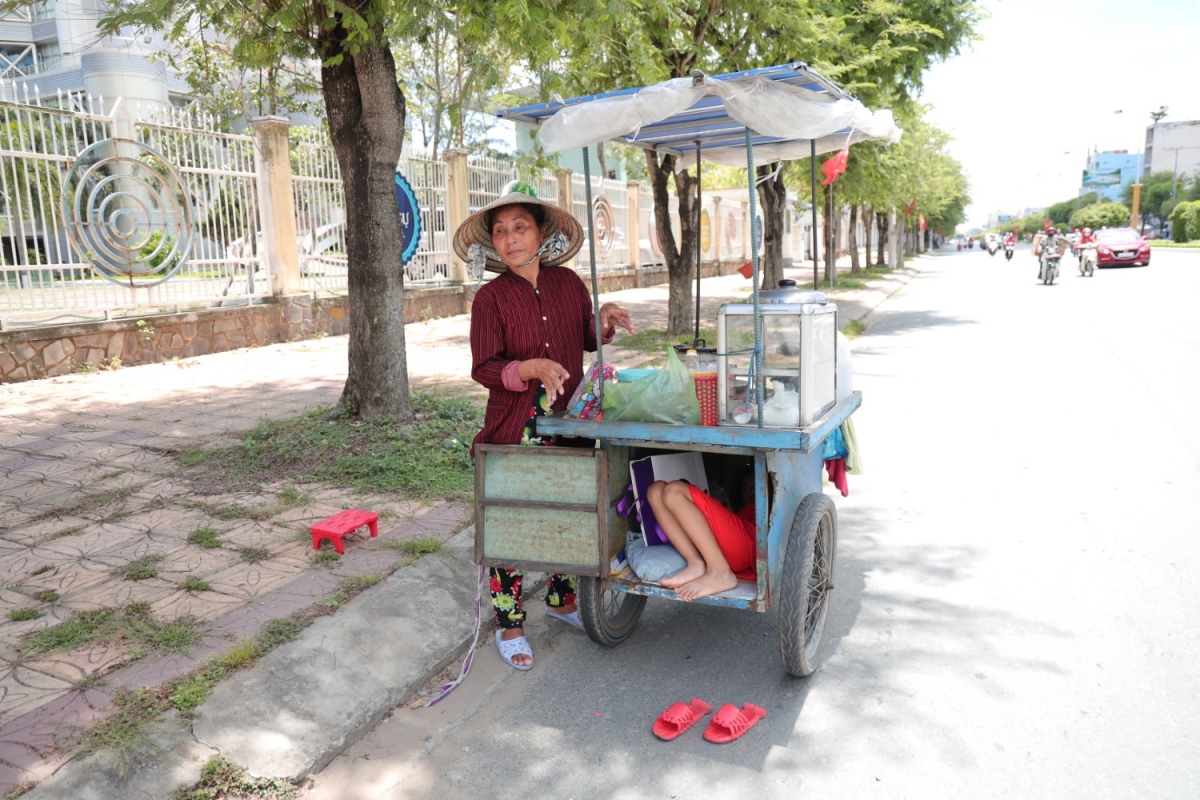 Bé Nghi ngủ trong xe đẩy hàng của chị Phượng.