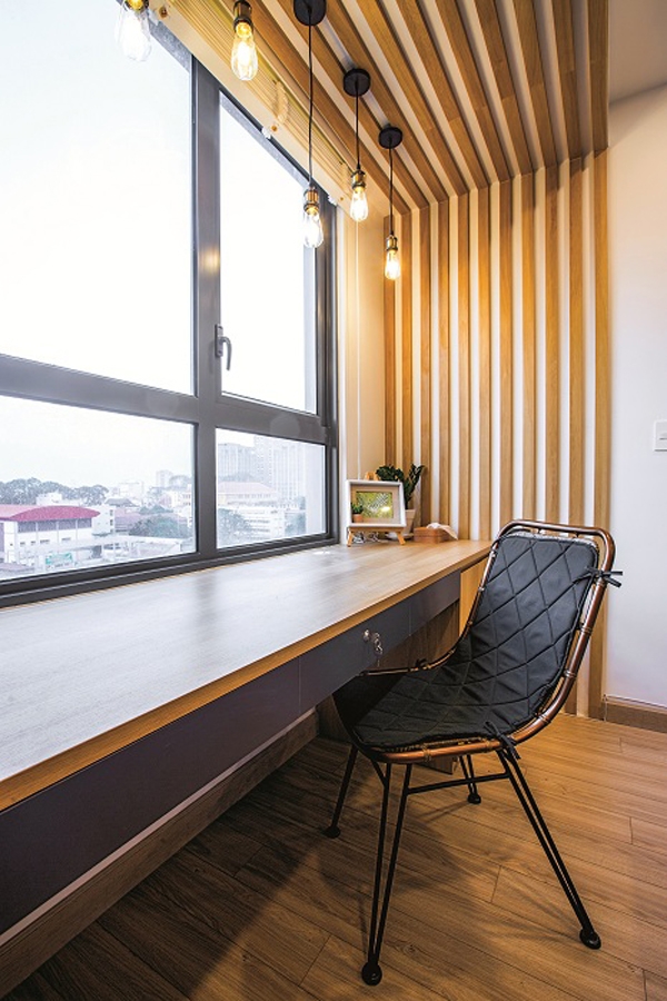 Bàn làm việc trong phòng ngủ chính được đặt sát cửa sổ để tận dụng ánh sáng trời.