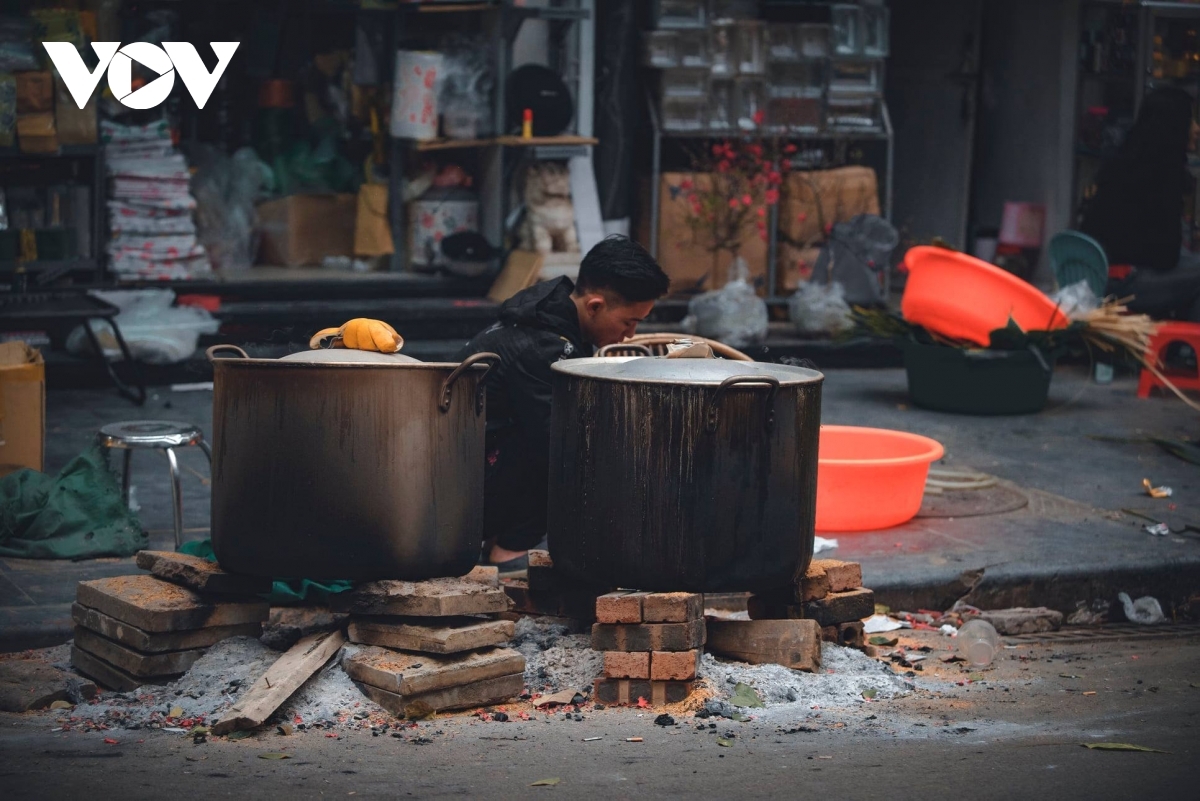 Cooking banh chung, a type of sticky rice cake during Tet, on the pavement