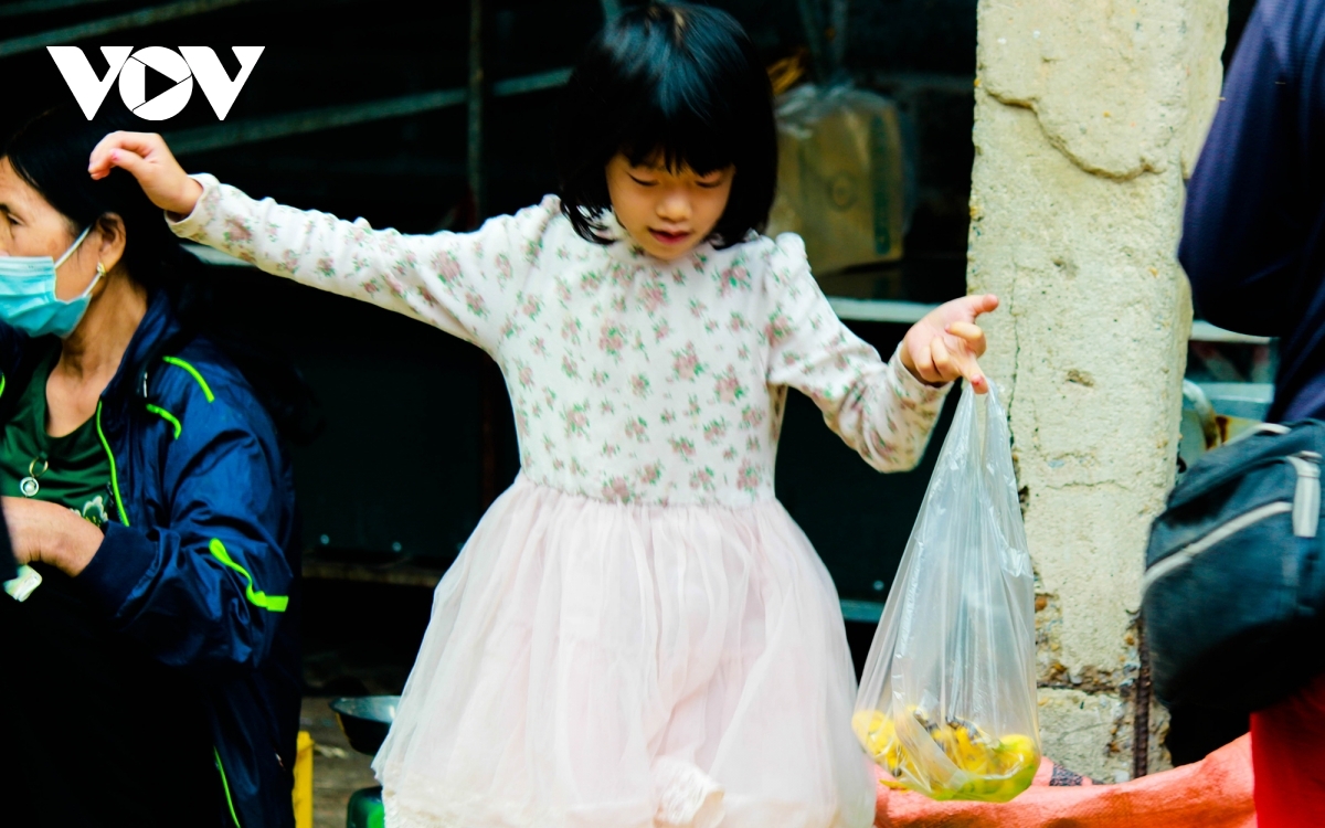 A child is happy to receive a gift from her mother after returning from the market.