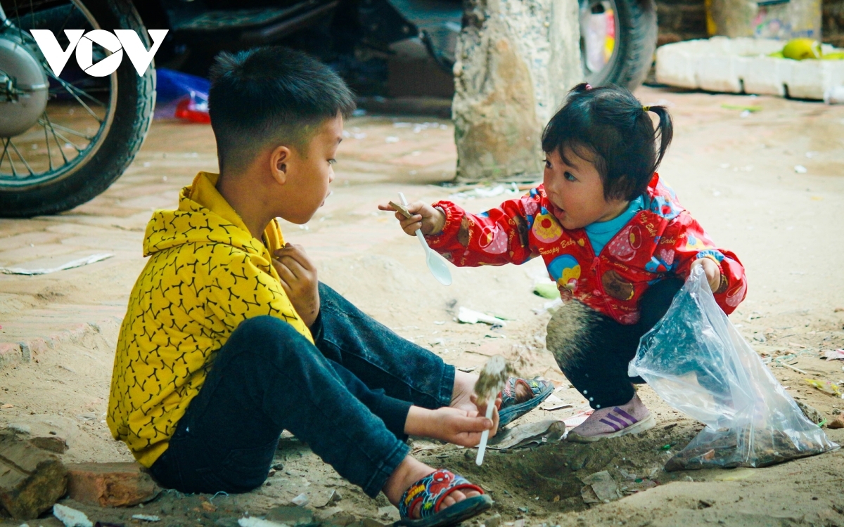 Children play together amid the bustling atmosphere of the Nom market on the final day of the 12th lunar month.