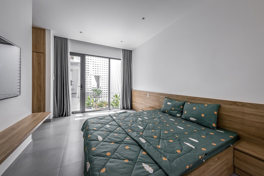 Nội thất phòng ngủ cũng đơn giản, thống nhất trong toàn nhà: Tường và trần màu trắng, sàn màu xám và đồ gỗ sáng màu với hình thức đơn giản.