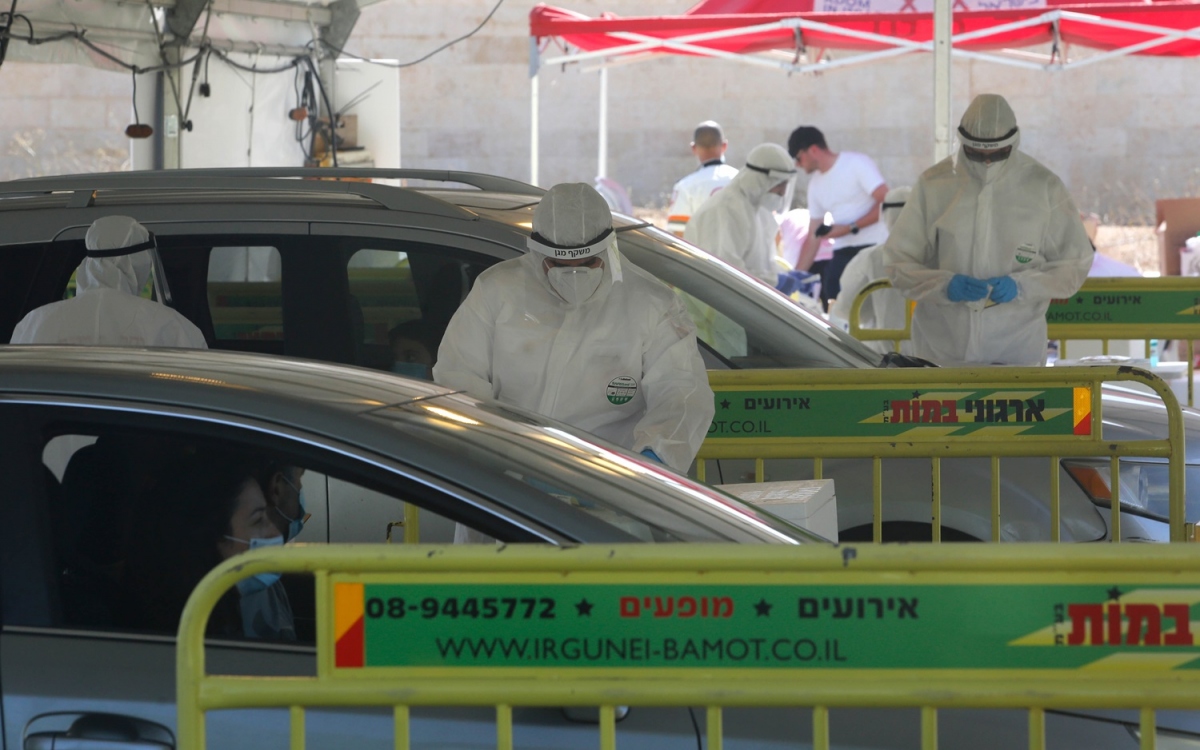 Nhân viên y tế Israel xét nghiệm Covid-19 cho người dân dưới hình thức đi ô tô qua điểm xét nghiệm. Ảnh: Stock.
