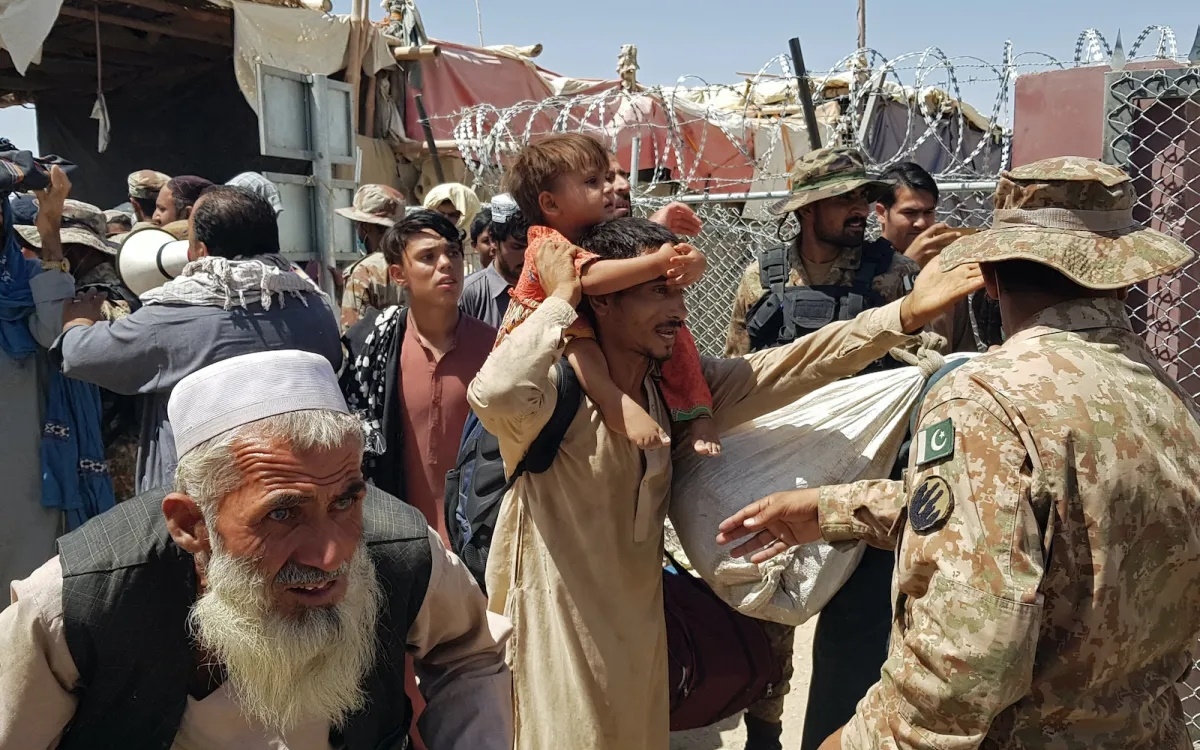 Binh sĩ Pakistan (bên phải) kiểm tra công dân Afghanistan tại chốt biên giới Pakistan-Afghanistan vào ngày 13/8/2021. Ảnh: AFP.