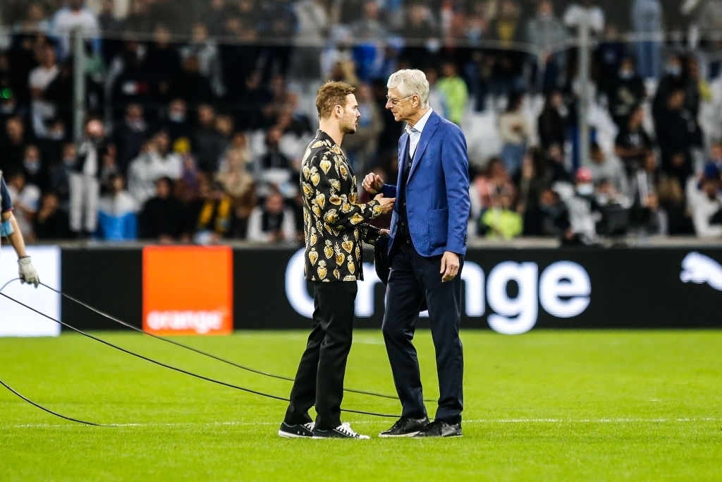 HLV Wenger chia sẻ với ca sĩ Matt Pokora sau trận. Toàn bộ số tiền thu được từ trận đấu này sẽ được phục vụ mục đích từ thiện./. 