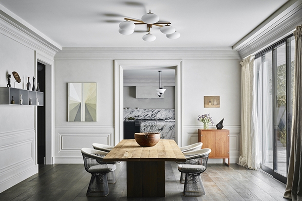 Sàn gỗ cứng bản rộng và các phiến đá cẩm thạch Carrara tạo cho phòng khách cảm giác hiện đại nhưng vẫn thoải mái. Cửa sổ kính suốt từ trần đến sàn đón ánh sáng tự nhiên và có tầm nhìn đẹp ra sân sau.