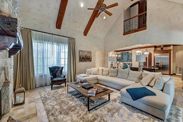 Phòng khách trang nhã với sofa lớn và lò sưởi bằng đá tạo ra một không gian ấm cúng.