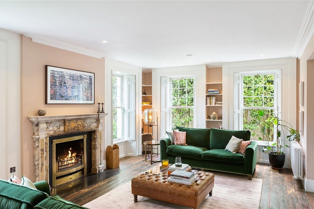  Lò sưởi bằng đá cẩm thạch và sofa màu xanh là điểm nhấn của không gian phòng khách.