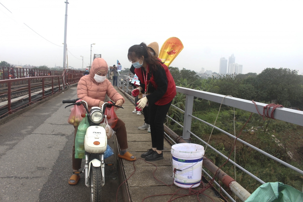 Tại cầu Long Biên, nhóm tình nguyện viên "Đường Táo quân" gồm nhiều bạn trẻ đã có mặt tại cầu Long Biên, Hà Nội, giúp đỡ người dân thả cá chép sau khi cúng ông Táo.