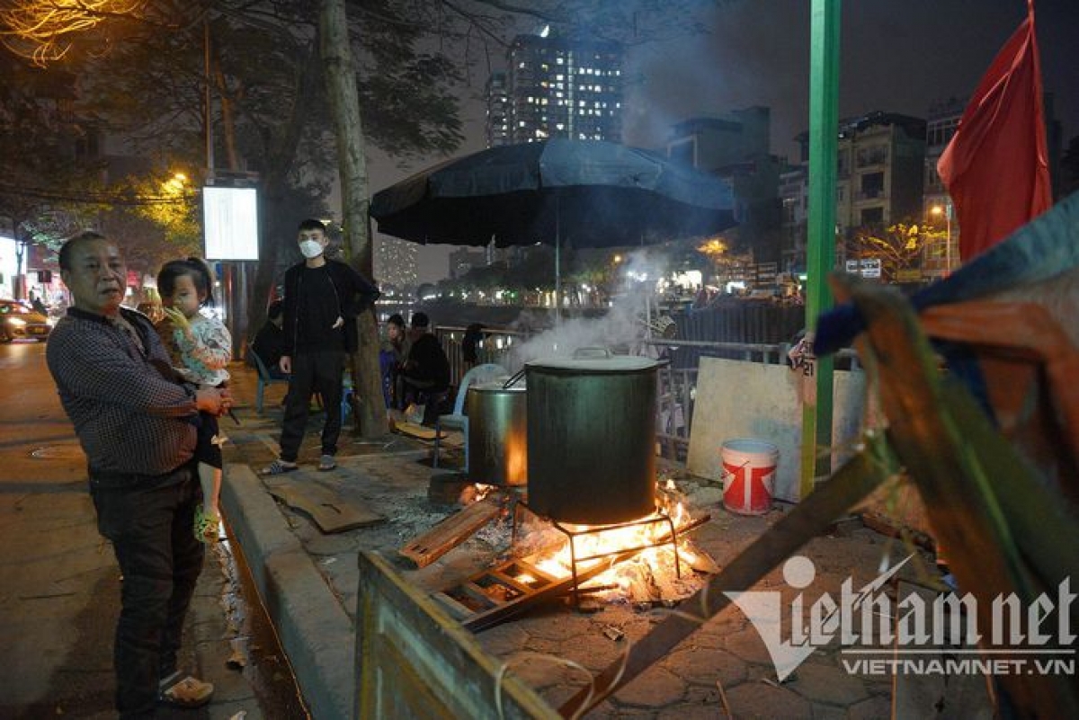 A family residing on Khuong Dinh street boil Chung cake on the pavement.