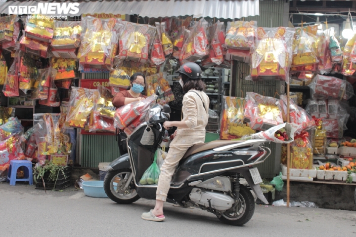 A similar quiet scene is recorded at Nhan Chinh market in Thanh Xuan district. A trader says she sells 10 sets of paper clothes for the Kitchen Gods on the morning of January 24, only one third of what she was able to sell last year.