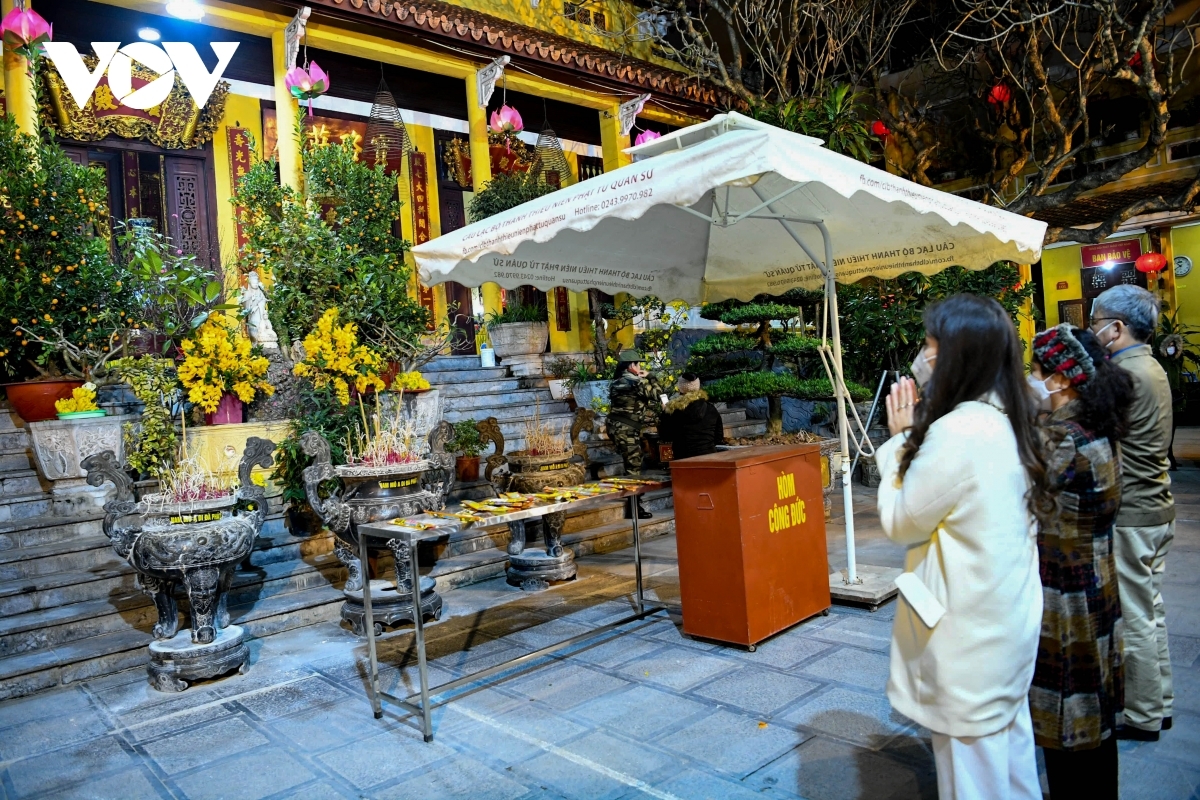 Local people keep their face masks on while praying for good fortune over the coming year.