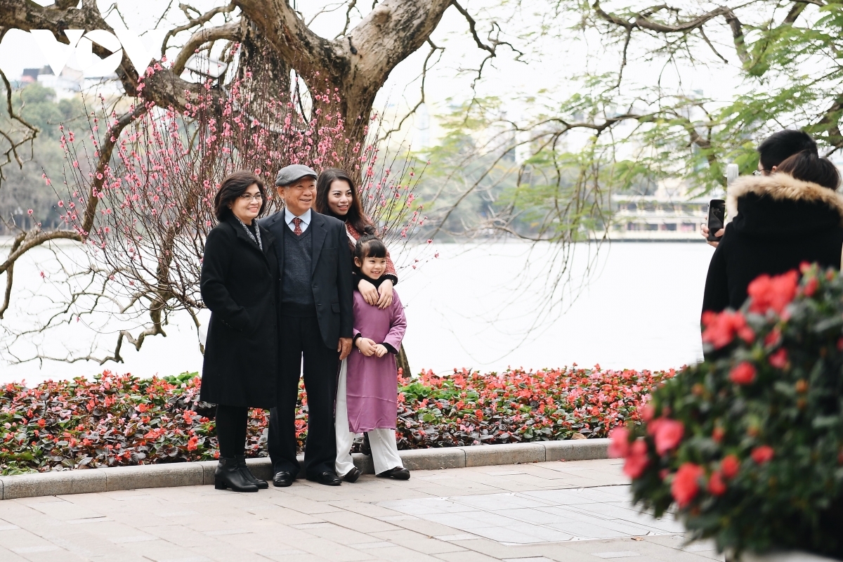 A family enjoys the peaceful and pleasant atmosphere as the surroundings of the Hoan Kiem iconic lake city are left totally quiet and deserted.