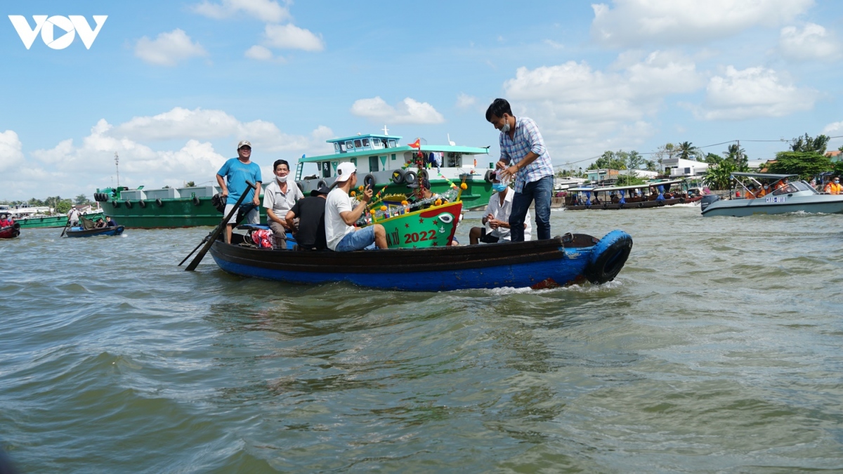 Từng dòng người đưa chiếc bè chuối bên trên là chiếc thuyền giấy, bên trong chứa đồ cúng như tiền, thức ăn, rau củ… khi mang ra ngã ba sông thả trôi theo dòng nước.