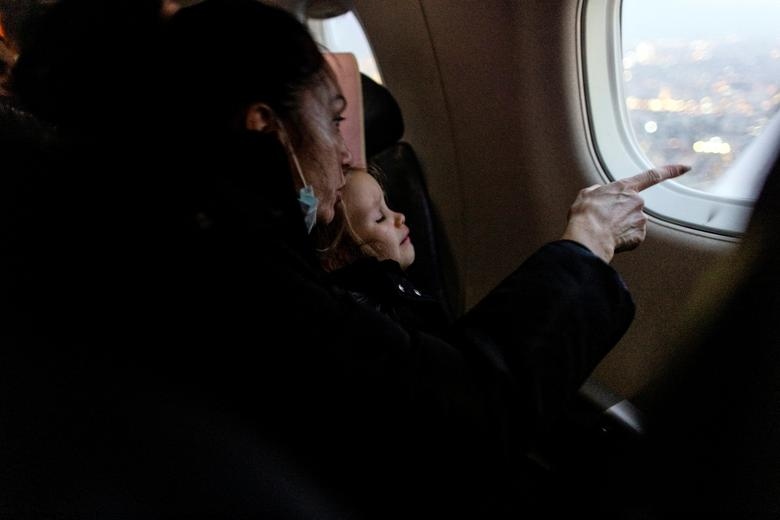 Một người tị nạn Ukraine đang chỉ cho con gái quang cảnh Tel Aviv nhìn từ cửa sổ máy bay trước khi máy bay hạ cánh xuống sân bay quốc tế Ben Gurion ở Lod gần Tel Aviv, Israel.