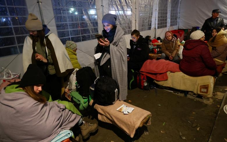 Những người dân chạy trốn khỏi cuộc tấn công của Nga vào Ukraine trú ẩn trong một căn lều sau khi đi qua biên giới từ Ukraine sang Ba Lan, tại trạm kiểm soát biên giới ở Medyka, Ba Lan. (Ảnh: Reuters)