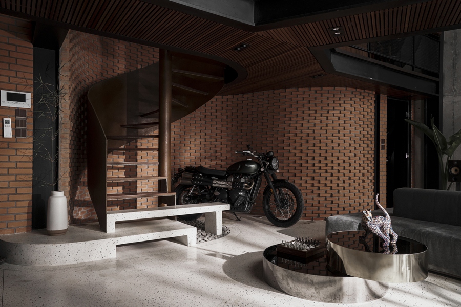 Cầu thang xoáy ốc lên tầng cũng là một cấu kiện kim loại. Dưới gầm cầu thang trưng bày chiếc xe phân khối lớn gắn nhiều kỷ niệm với chủ nhân.