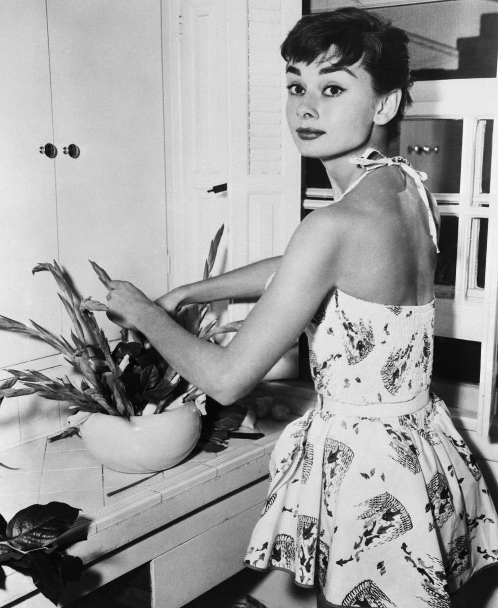 Nữ diễn viên Audrey Hepburn trông vô cùng xinh đẹp và rạng rỡ khi sắp xếp những bông hoa trong căn hộ của cô tại NewYork năm 1954.
