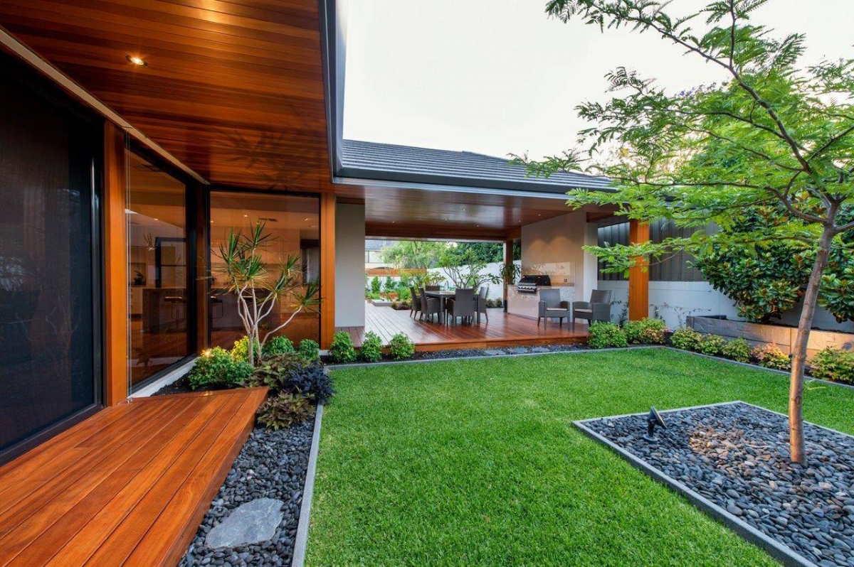 Một căn nhà khác với khoảng sân rộng được bao phủ bởi một thảm cỏ, tạo ra không gian mở thoáng mát, dễ chịu cho phòng ăn của gia đình.