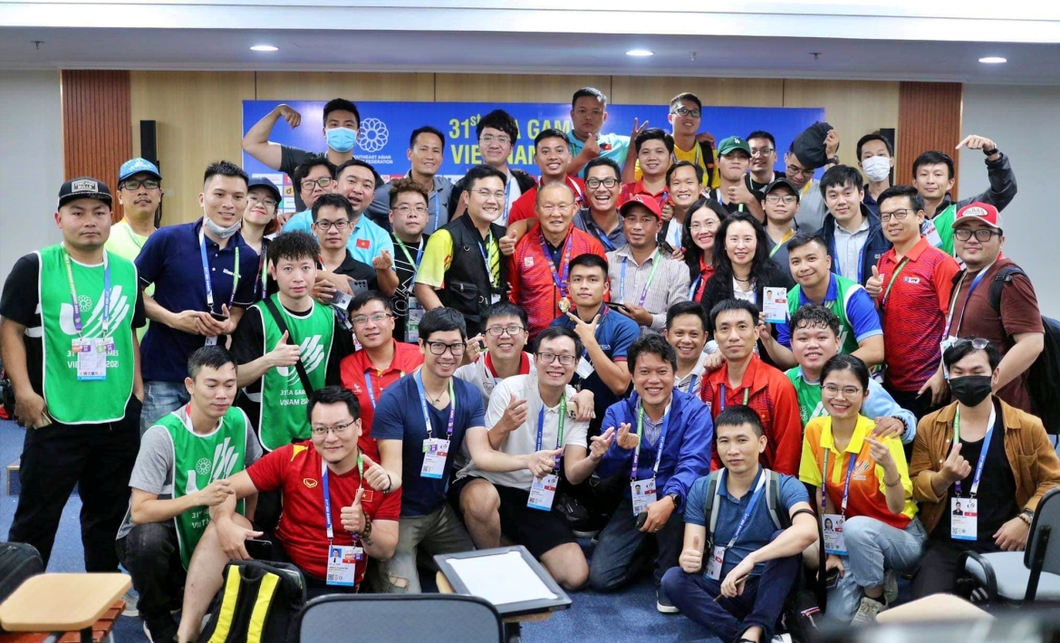 Phóng viên Bảo Long (áo trắng ngồi giữa đeo kính), phóng viên Ngọc Chính (VTC, người đứng sau HLV Park Hang Seo), phóng viên Khuất Tú (VOV2, đứng cách HLV Park Hang Seo 1 người về bên trái), quay phim Tiến Dũng (VTC, áo xanh hàng ngồi) chụp ảnh lưu niệm với HLV Park Hang Seo và các phóng viên tại phòng họp báo sau trận chung kết môn bóng đá nam SEA Games 31 diễn ra ở sân vận động quốc gia Mỹ Đình (Hà Nội).