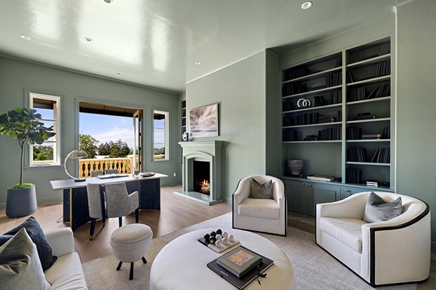 Phòng làm việc có tông màu xanh lục đơn sắc, có lò sưởi, giá sách gắn sẵn và sân hiên để thư giãn.