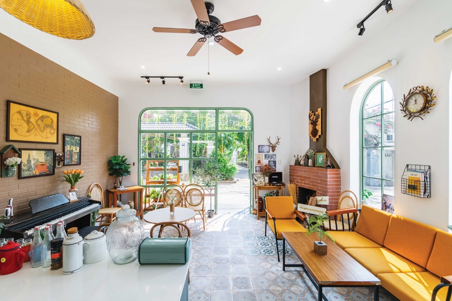 Những ô cửa lớn mang lại ánh sáng tự nhiên tràn ngập. Góc phòng có một chiếc lò sưởi theo đúng phong cách Địa Trung Hải. Đồ trang trí nội thất được bố trí khéo léo làm không gian sinh động, tiện ích mà không quá rối.