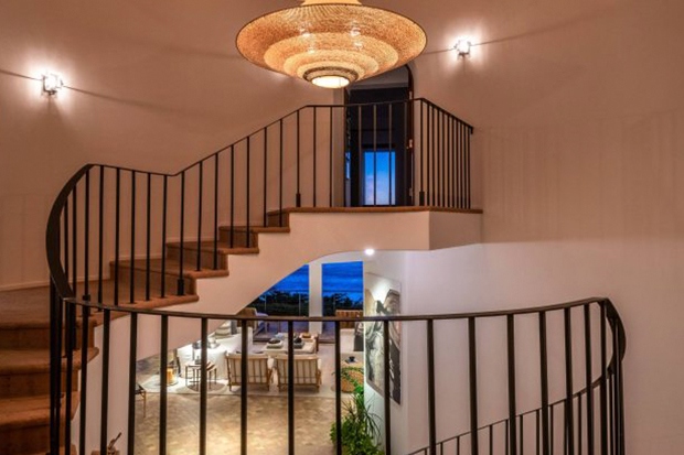 Lối dẫn lên tầng 2 được trang trí với đèn chùm ấn tượng.