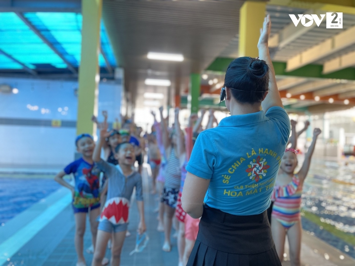 Các em được hướng dẫn kỹ các động tác khởi động và hô to khẩu hiệu “Học bơi vui vẻ - Chiến binh dũng cảm” để tạo không khí vui tươi, sẵn sàng cho một buổi học đầy tiếng cười.