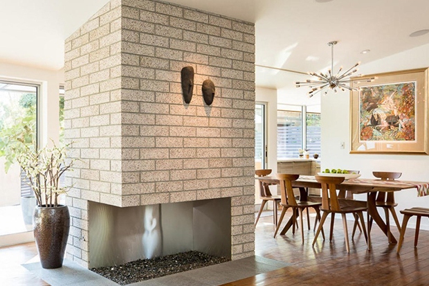 Lò sưởi chạm khắc ngăn chia khu vực phòng khách và phòng ăn trong không gian mở.
