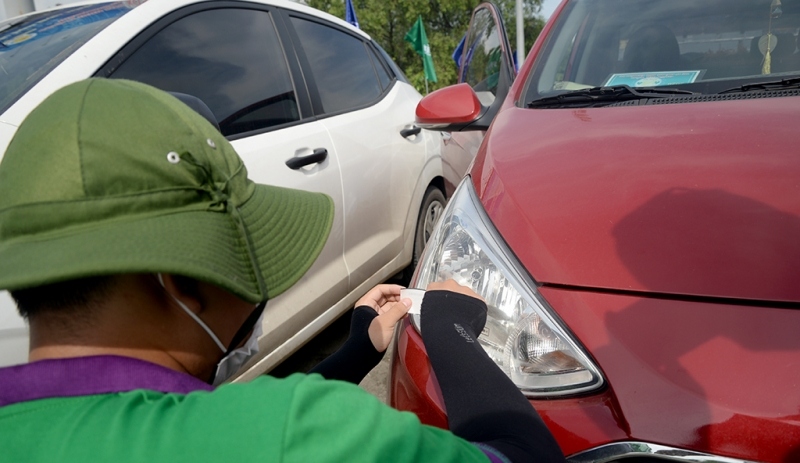 Nhân viên dán thẻ ETC tại trạm thu phí Long Phước. (ảnh G.A)