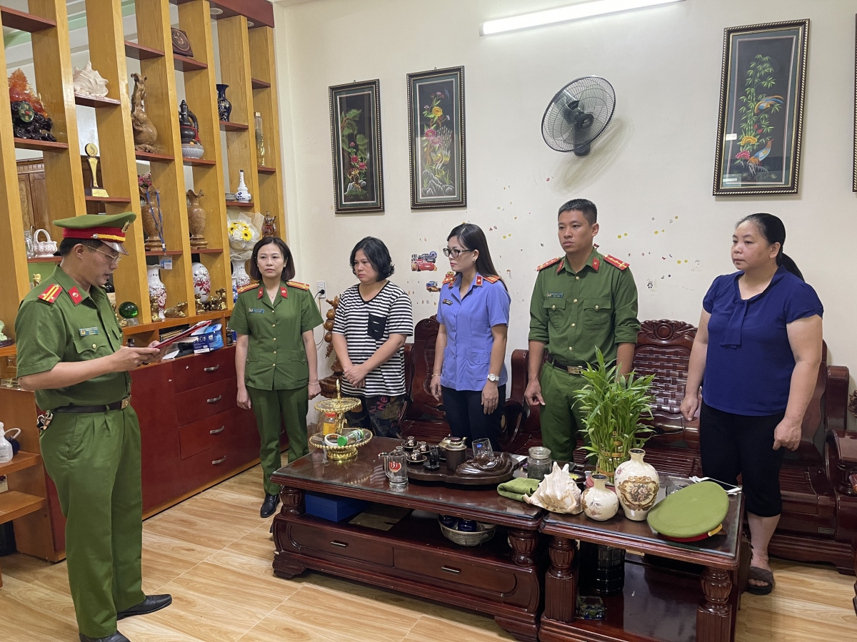 Công an đọc lệnh bắt Trần Thị Hà (áo kẻ ngang).