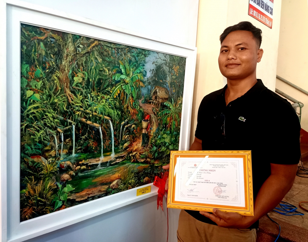 Họa sĩ trẻ Y Buih Niê Kdăm bên tác phẩm "Kpin Ea".