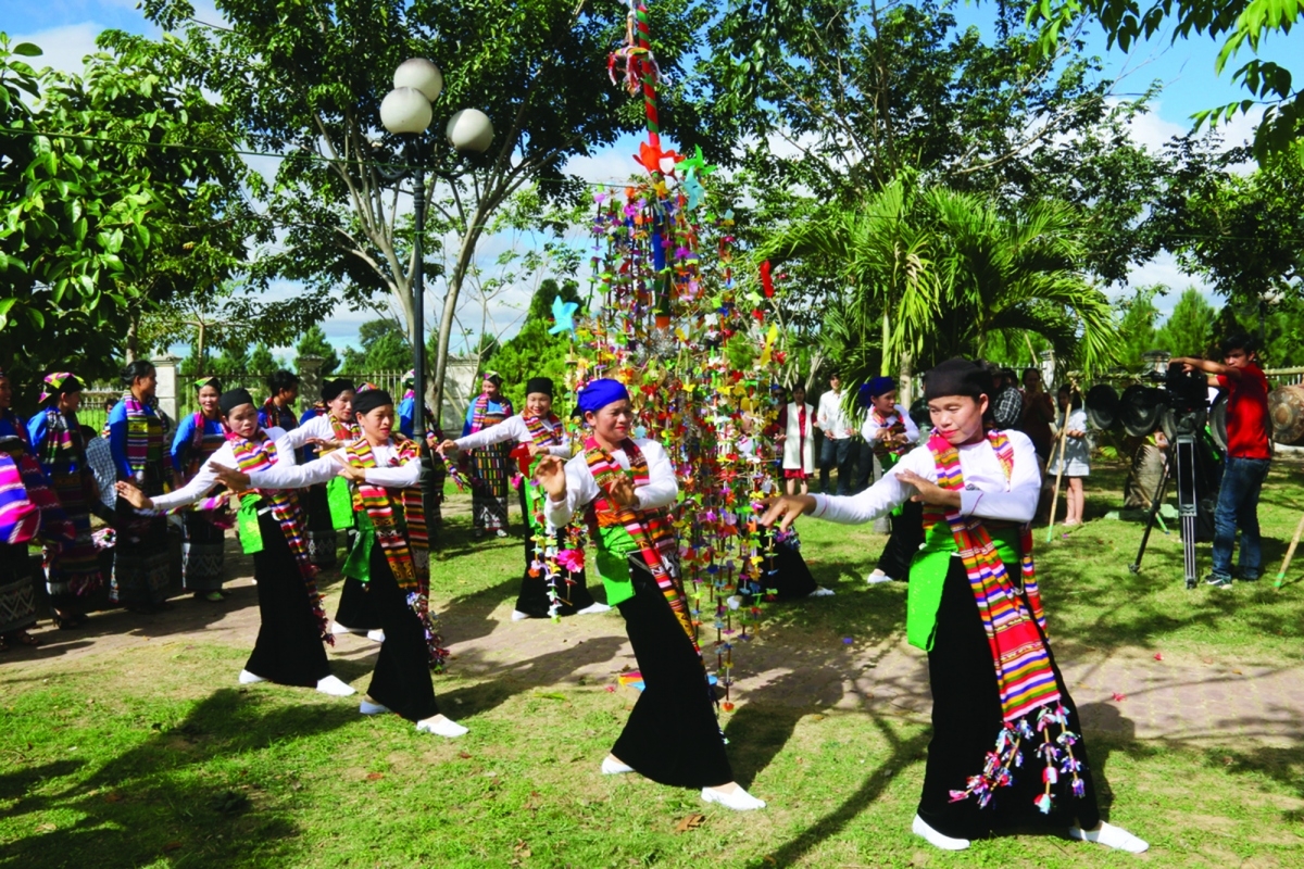 Nam nữ thanh niên dân tộc Thái trình diễn hát múa ăn mừng dưới cây bông.