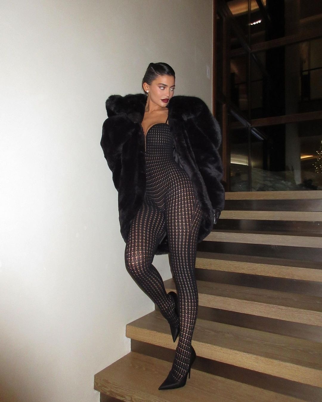 Cô diện bodysuit cùng áo khoác lông. 