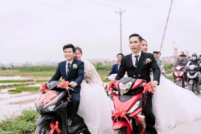 Vì nhà gần nhau nên 2 chú rể đã quyết định dùng xe máy để đi rước dâu. Cả 2 hẹn nhau ở ngã 3 đường rồi cùng đón dâu về nhà (Ảnh: Xuân Quang).