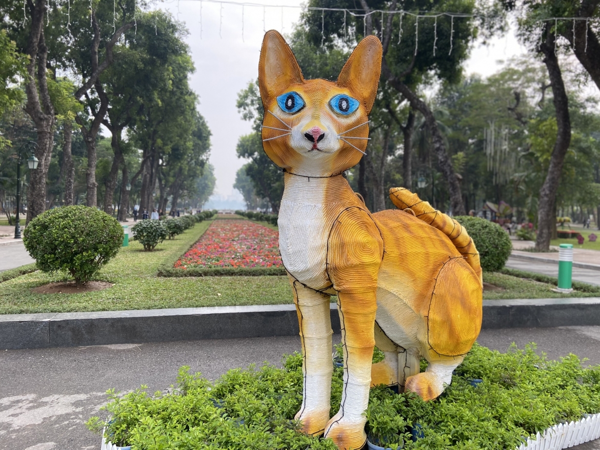 Tại Thủ đô Hà Nội, linh vật mèo chào đón Xuân Quý Mão 2023 được đặt ở Công viên Thống Nhất cũng có hình dạng lạ mắt. Nhiều người nhận xét, mô hình mèo này trông giống cáo. Râu của mèo cũng bị liên tưởng tới râu chuột, dáng ngồi của lại giống thỏ. (Ảnh: Kim Nhung)