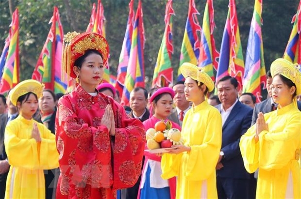 Chủ tế nữ mặc bộ lễ phục mầu đỏ thực hiện nghi thức tế lễ truyền thống. (Ảnh: Trung Kiên/TTXVN)