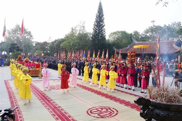 Đội tế nữ quan trong trang phục áo dài, đầu đội khăn kim tuyến, thắt lưng dải lụa, chân đi hài thêu thực hiện nghi thức tế lễ truyền thống. (Ảnh: Trung Kiên/TTXVN)