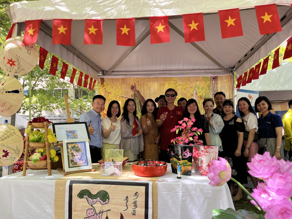Đại sứ Nguyễn Tất Thành cùng các nhân viên ĐSQ Việt Nam tại Australia chụp ảnh tại gian hàng của Việt Nam. Nguồn ĐSQ Việt Nam tại Australia.