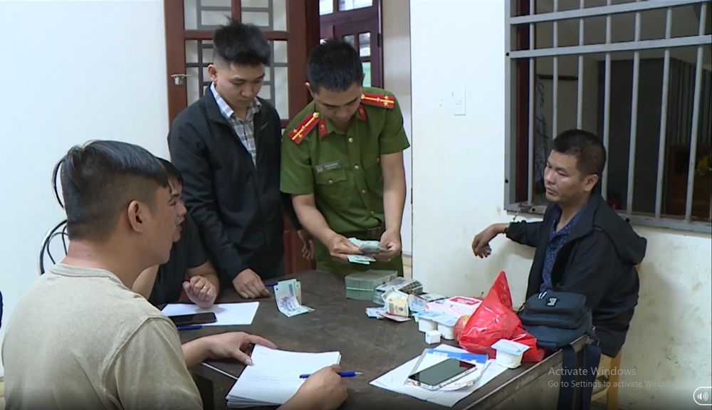 Lực lượng chức năng lấy lời khai và kiểm đếm số tiền nghi phạm mang theo.