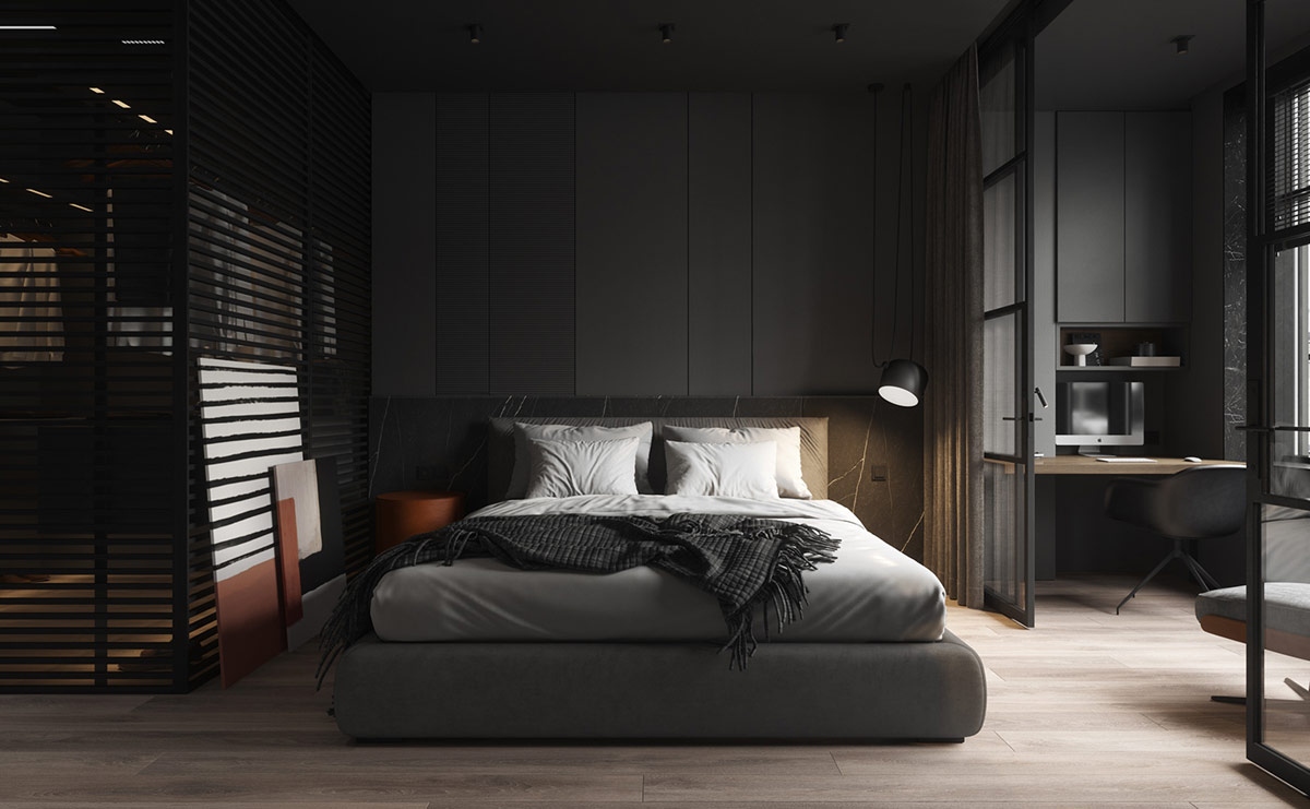 Trong bộ tổng thể, một chiếc giường bọc nệm được hỗ trợ bởi một bức tường đầu giường bằng đá cẩm thạch màu đen. Đèn treo phòng ngủ làm nổi bật đường vân tự nhiên trong đá.