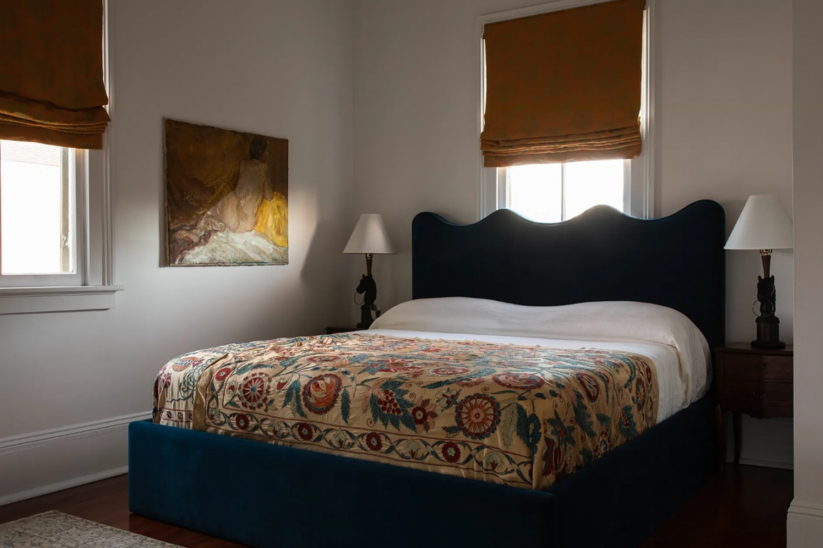 Phòng ngủ đơn giản với họa tiết hoa lá trên ga trải giường.