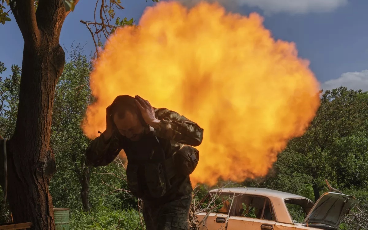 Lính Ukraine bịt tai khi bắn súng cối về phía vị trí quân Nga gần Bakhmut. Ảnh: AP.