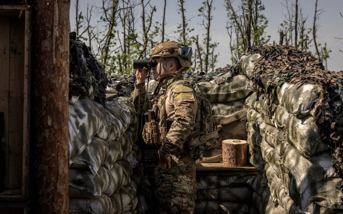 Lính Ukraine quan sát bằng ống nhòm từ trong chiến hào ở mặt trận miền Đông. Ảnh: New York Times.