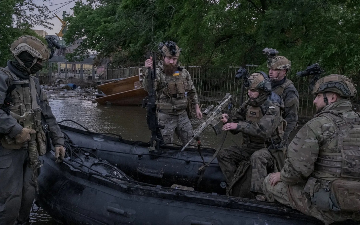 Lính Ukraine đi tuần bằng xuồng ở vùng Kherson ngập lụt do vỡ đập Kakhovka. Ảnh: New York Times.