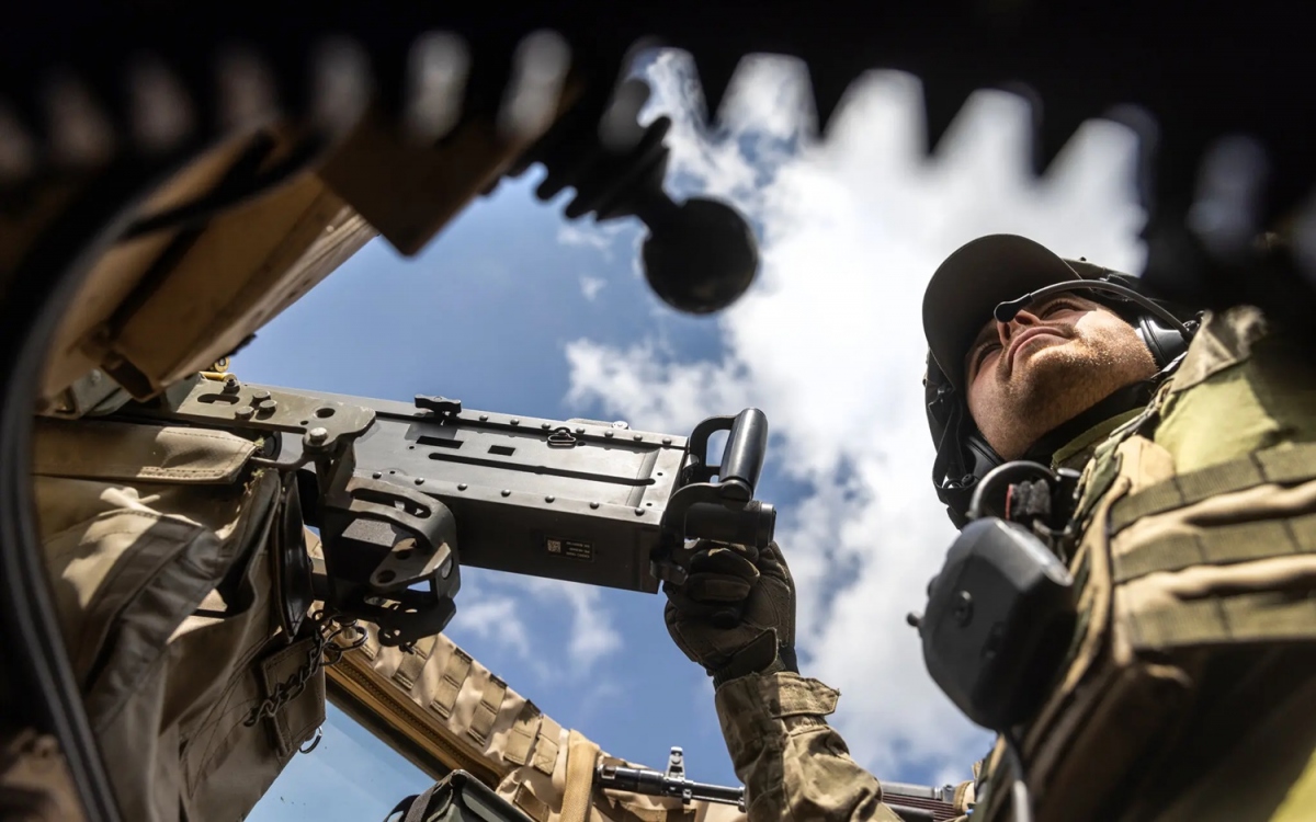 Lính Ukraine cầm súng máy trong xe thiết giáp. Ảnh: Nytimes.