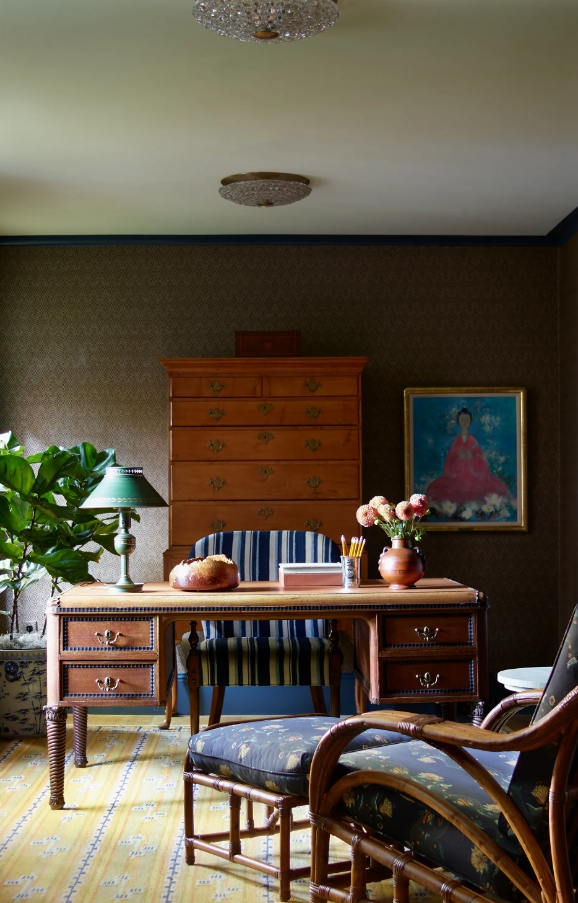 Phòng làm việc mang vẻ ấm cúng với sự kết hợp của hai màu vàng - xanh. Bàn làm việc mang hơi thở cổ điển của những năm 1960, kết hợp hài hòa với chi tiết kẻ sọc xanh trên ghế.